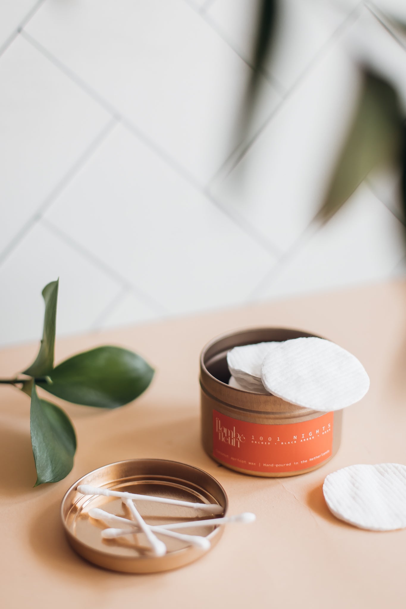 Vegan Scented Candle - Oriental 1001 Nights - Non Toxic. Candle with cotton swabs and cotton pads on a beige surface with a plant leaf.