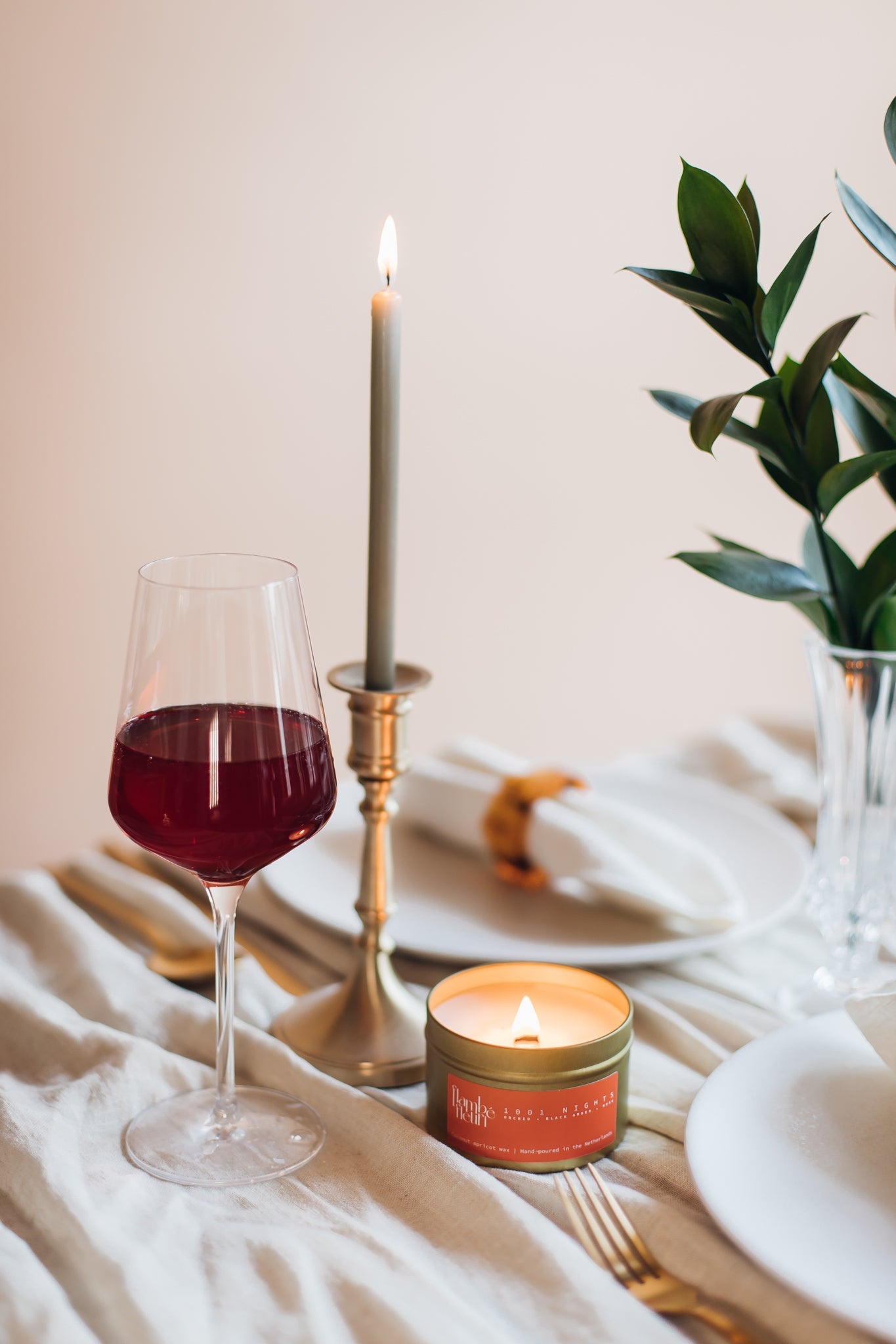 Vegan Scented Candle - Oriental 1001 Nights - Non Toxic. Lit candle, and gold candle holder on a table setting.