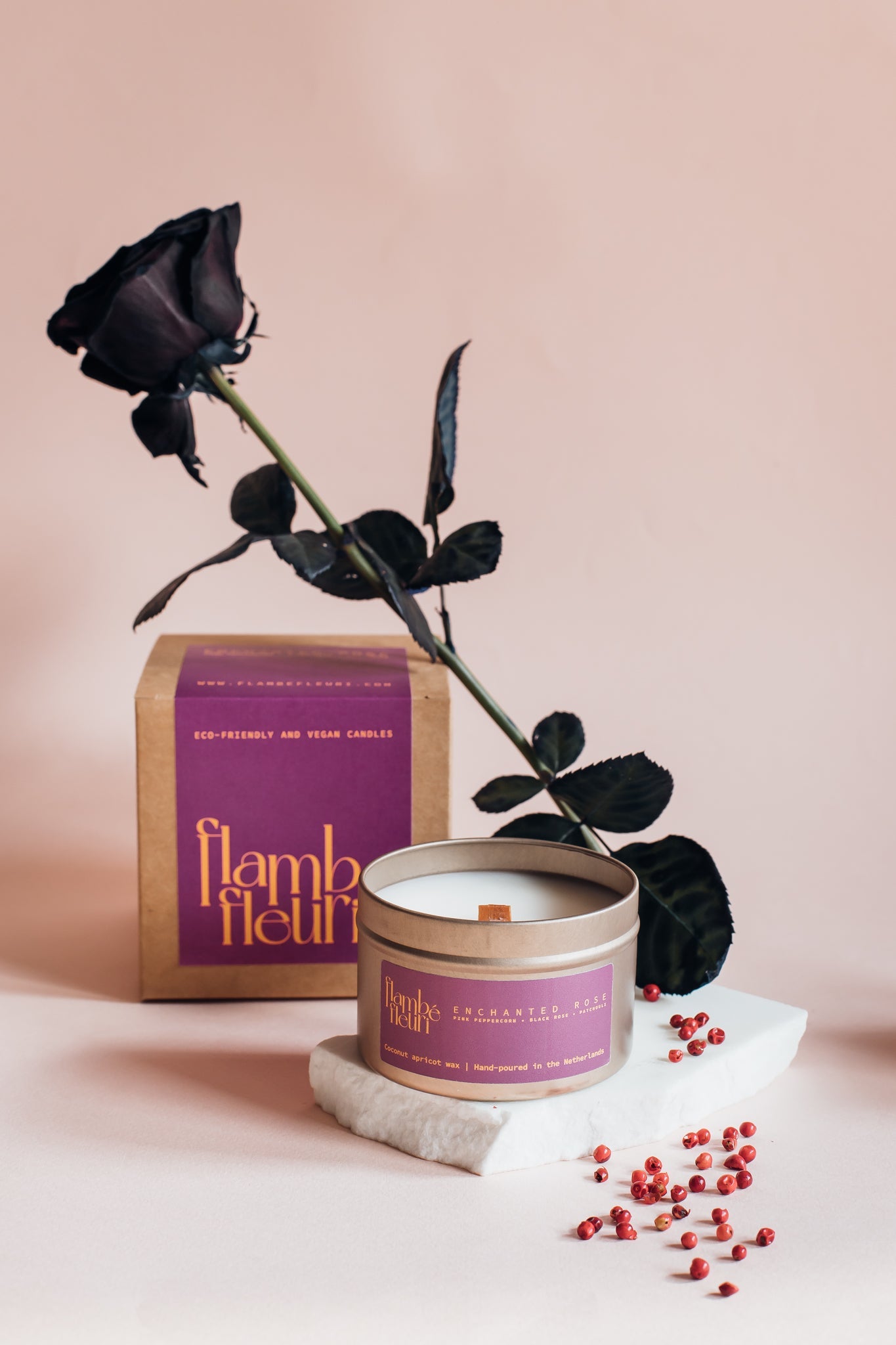 Non Toxic Vegan Candle with black rose and 'Flambé' packaging on a light pink background. Wooden wick